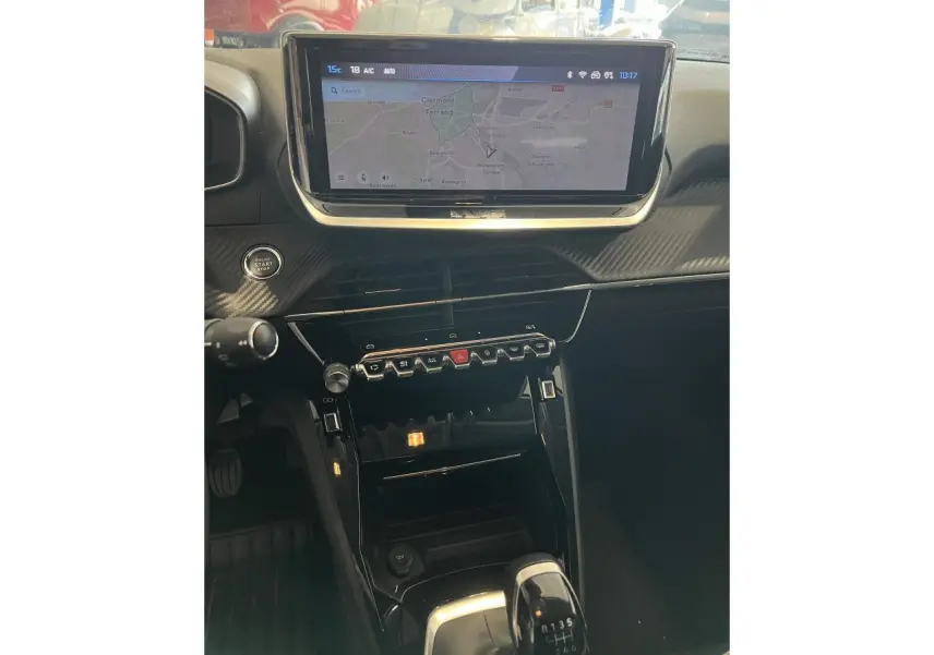 Intérieur Peugeot 208 2024, vue centrale sur console avec écran tactile, commandes piano et levier de vitesse manuel.