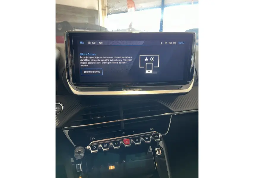 Vue rapprochée de la console centrale et écran tactile du Peugeot 208 gris clair Selenium, avec commandes et finition carbone.