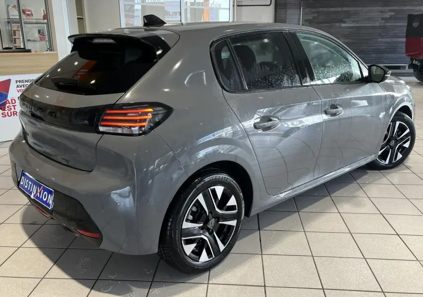 Vue 3/4 arrière droite de la Peugeot 208 gris clair Selenium avec feux arrière LED 3 griffes et jantes alliage 16 pouces.