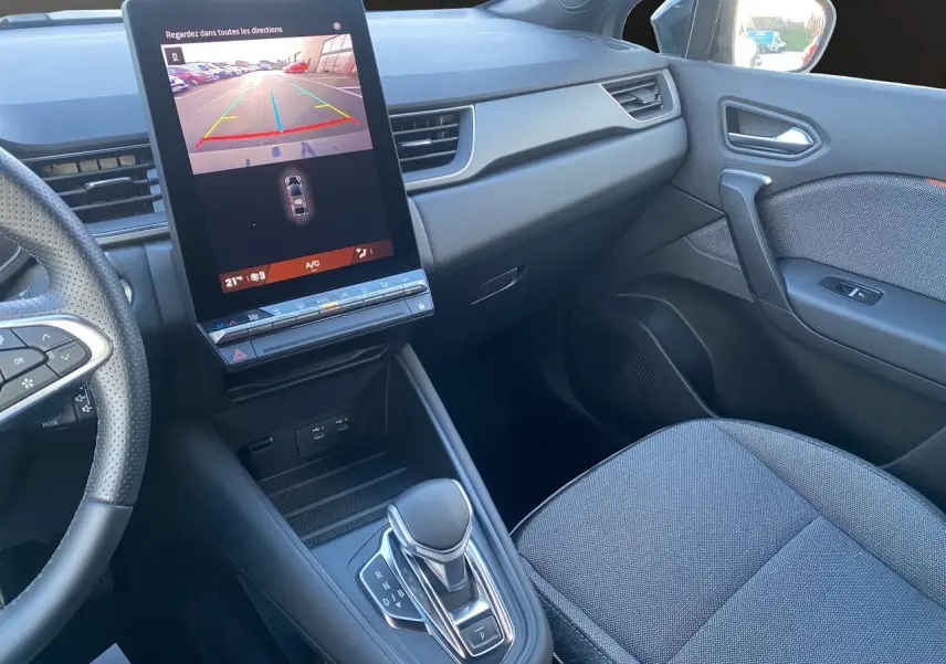 Vue intérieure côté passager avant de la Renault Symbioz gris Casiopee, avec écran tactile vertical et levier de vitesse automatique.