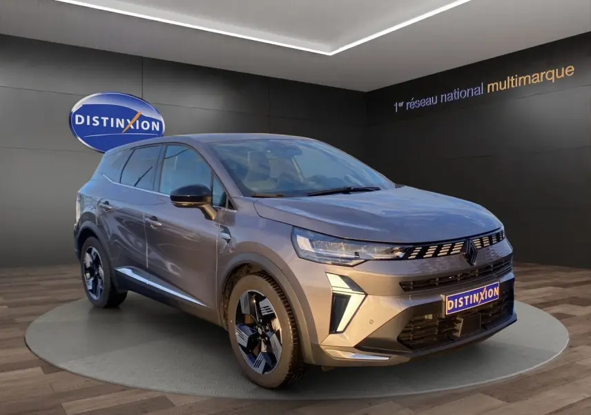 Renault Symbioz gris Casiopee en 3/4 avant droit, jantes alliage noires et calandre moderne avec logo Renault.