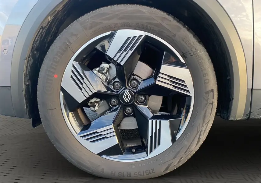 Gros plan sur la jante alliage 18'' diamantée noire et grise du côté gauche d'une Renault Symbioz gris Casiopee.