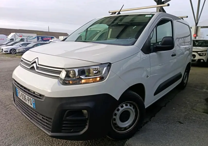 Vue 3/4 avant droit d’un Citroën Berlingo blanc 2020 avec calandre noire et barres de toit métalliques.