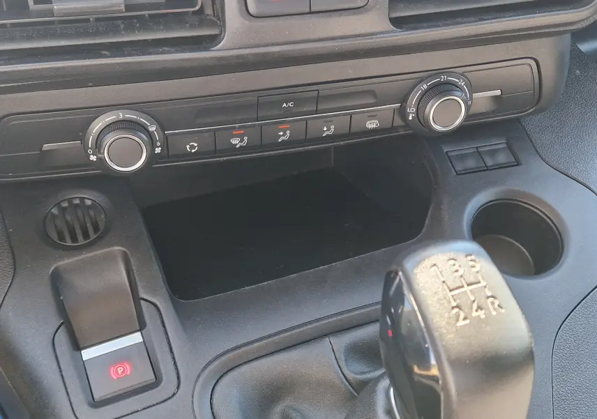 Vue rapprochée du tableau de bord du Citroën Berlingo blanc 2020, avec commandes climatisation et levier de vitesse manuel.