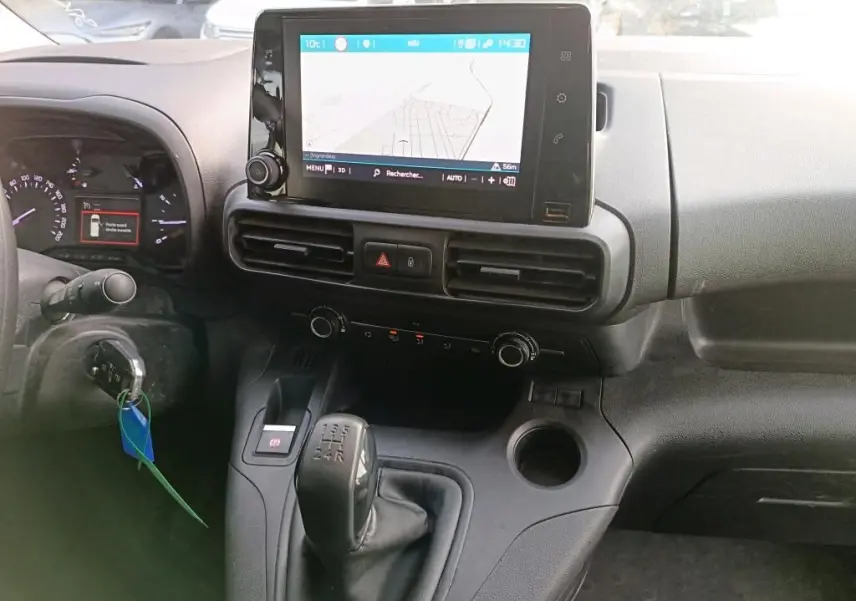 Vue intérieure du tableau de bord du Citroën Berlingo 2020 avec écran tactile, commandes de climatisation et levier de vitesse manuel.