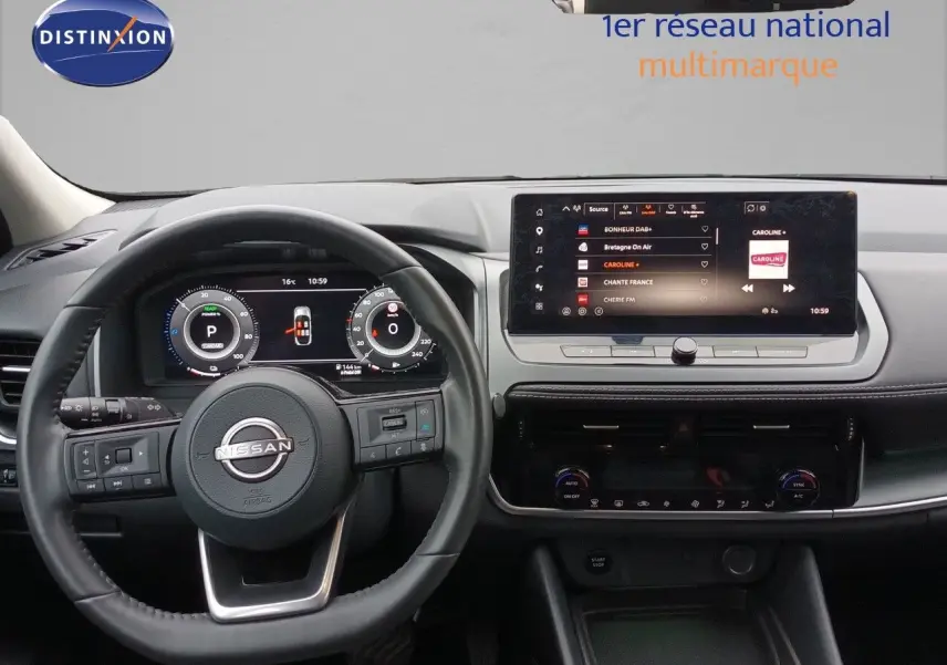 Vue intérieure centrée sur le tableau de bord et le volant du Nissan Qashqai noir avec écran tactile et commandes digitales.