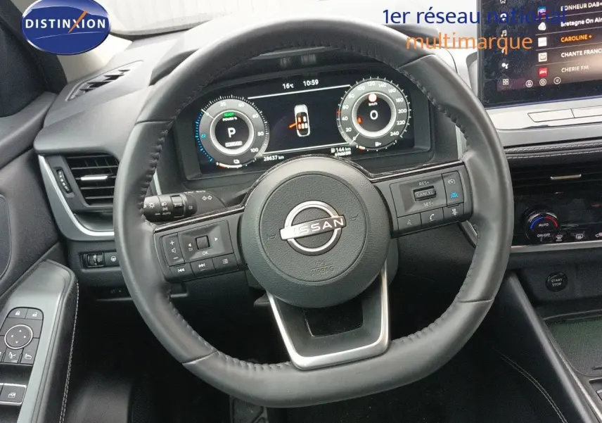 Vue intérieure centrée sur le volant cuir noir du Nissan Qashqai e-POWER 2025 avec tableau de bord digital et écran tactile.