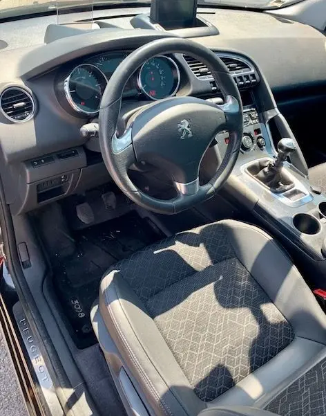 Intérieur de la Peugeot 3008 1.6 HDI115 Allure 2014, vue côté conducteur montrant volant, tableau de bord et levier manuel.