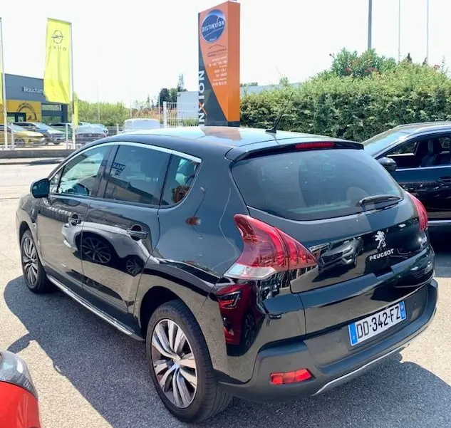 Peugeot 3008 noir 2014 vue 3/4 arrière côté gauche, avec feux arrière distinctifs et jantes alliage.