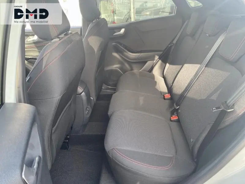 Vue intérieure arrière côté gauche du Ford Puma 2026 avec sièges tissu noir et surpiqûres rouges.