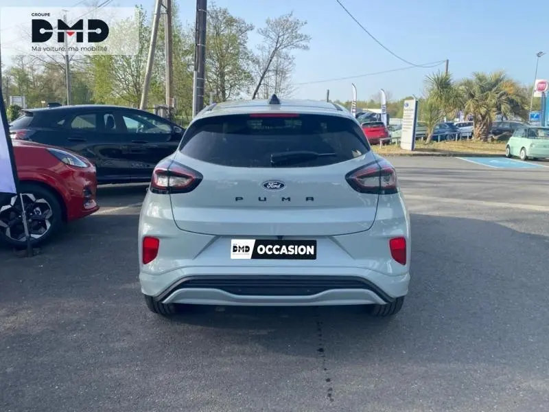 Vue arrière d'un Ford Puma gris Cactus stationné sur un parking extérieur, avec feux arrière LED visibles.