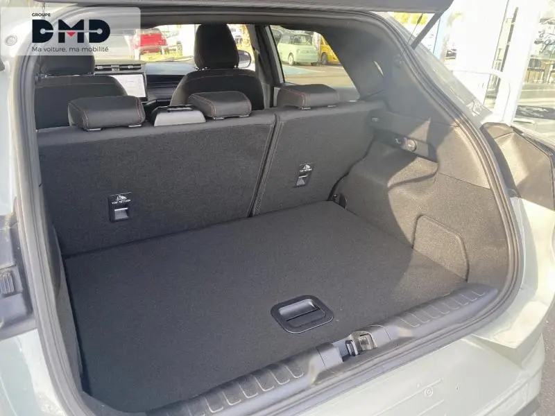 Coffre ouvert vu de l'arrière d'un Ford Puma gris Cactus, montrant l'espace de chargement et la banquette rabattue.