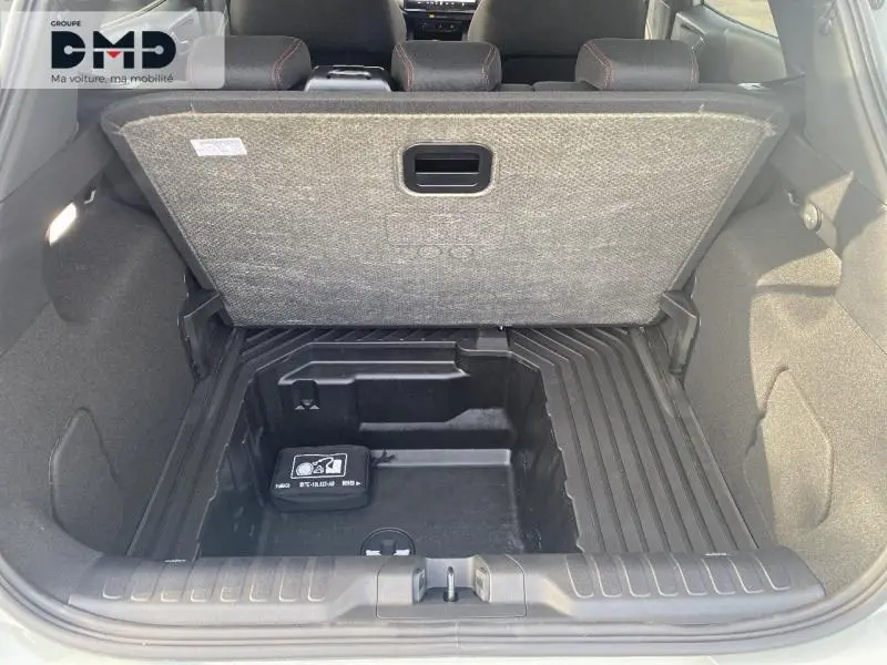 Coffre ouvert de Ford Puma gris Cactus montrant le rangement sous plancher et la moquette grise.