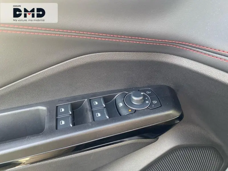Détail des commandes de lève-vitres et rétroviseurs sur la porte côté conducteur du Ford Puma gris Cactus.