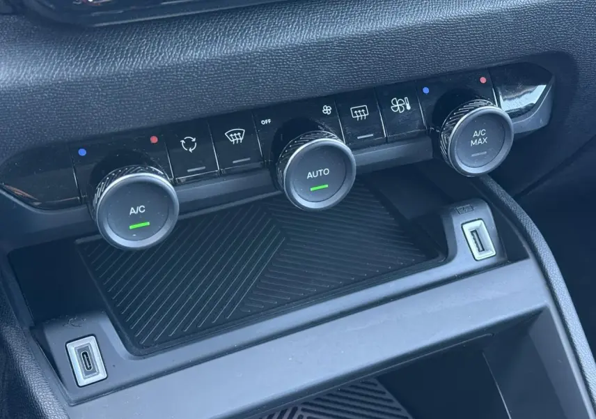 Commandes de climatisation automatique avec boutons rotatifs et ports USB dans l'habitacle noir du Citroën C4 X 2024