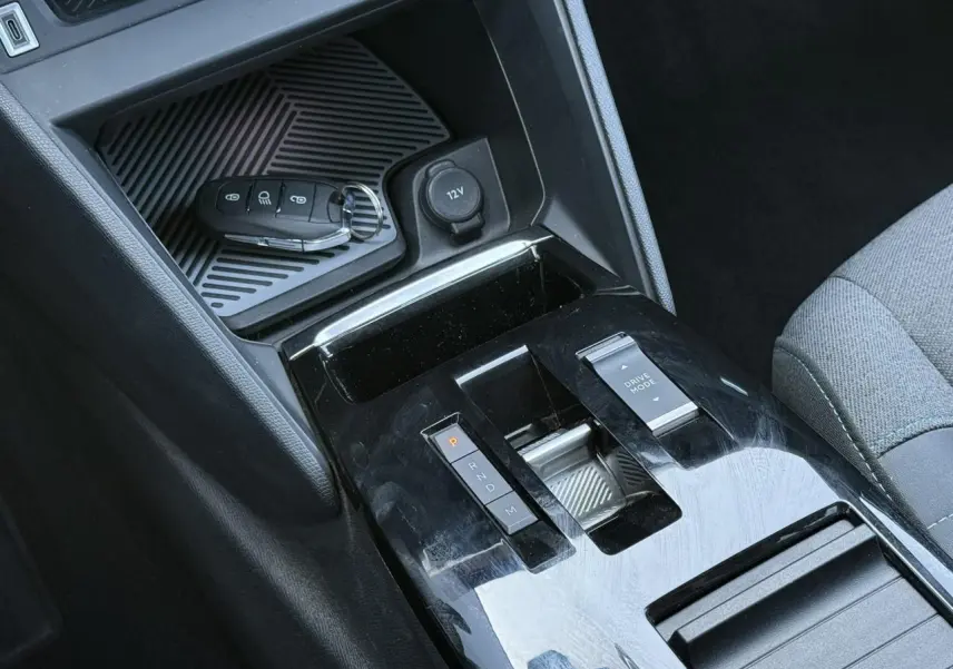 Gros plan sur la console centrale noire brillante de la Citroën C4 X 2024 avec clé et commandes de boîte auto.