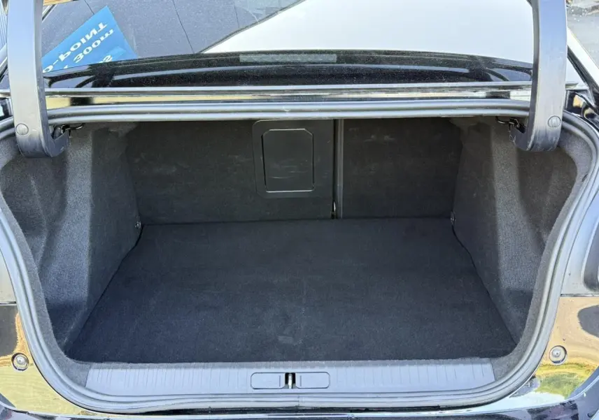 Coffre ouvert vu de l'arrière d'une Citroën C4 X 2024 noir Perla, espace de chargement vide et propre.