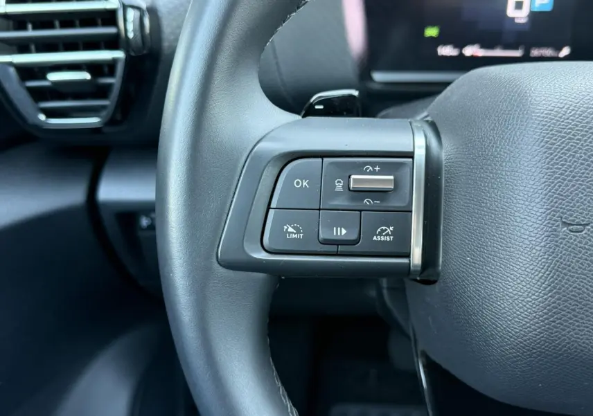 Gros plan sur les commandes du régulateur adaptatif au volant cuir noir du Citroën C4 X 2024.