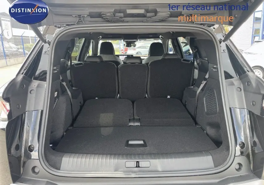 Coffre ouvert du Peugeot 5008 noir perle métal, vue arrière montrant banquette arrière partiellement rabattue et espace de chargement.