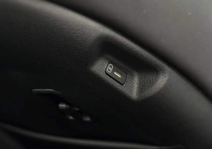 Prise USB-C intégrée dans l'accoudoir central avant du Kia Sportage gris perle 2025, finition Style.