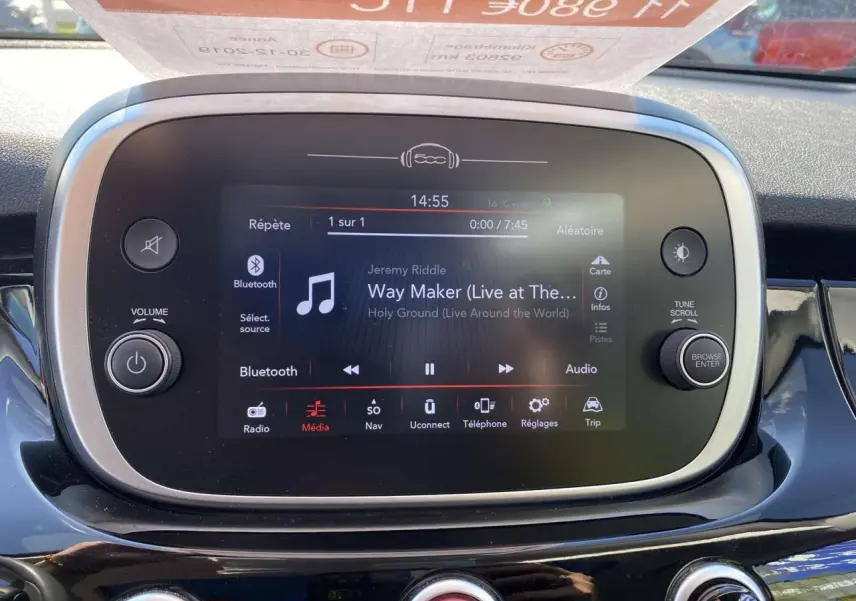 Écran tactile central de la FIAT 500X noir, affichant la lecture Bluetooth d'une musique, vue de face intérieure.