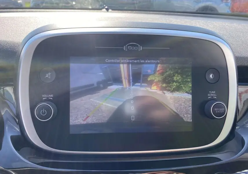 Écran central de la Fiat 500X noir montrant la caméra de recul avec lignes de guidage colorées.