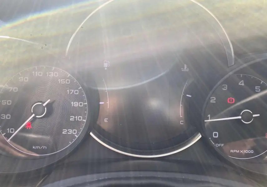 Tableau de bord de Fiat 500X noir 2019 avec compteur de vitesse, compte-tours et jauges sous un fort éclat lumineux.