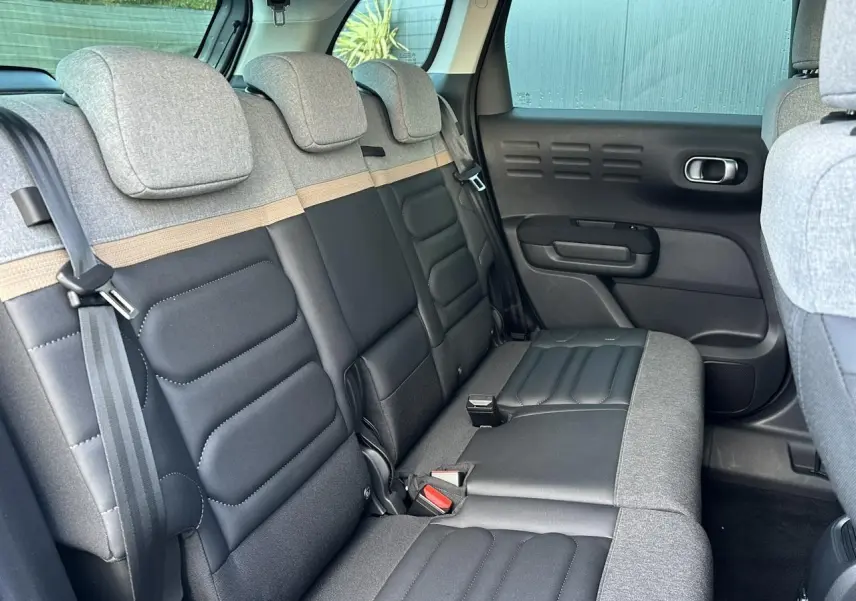 Vue intérieure de la banquette arrière bicolore gris clair et noir du Citroën C3 Aircross 2024 côté droit.