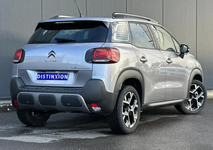 Citroën C3 Aircross gris Artense vue 3/4 arrière droit avec jantes alliage et barres de toit noires.