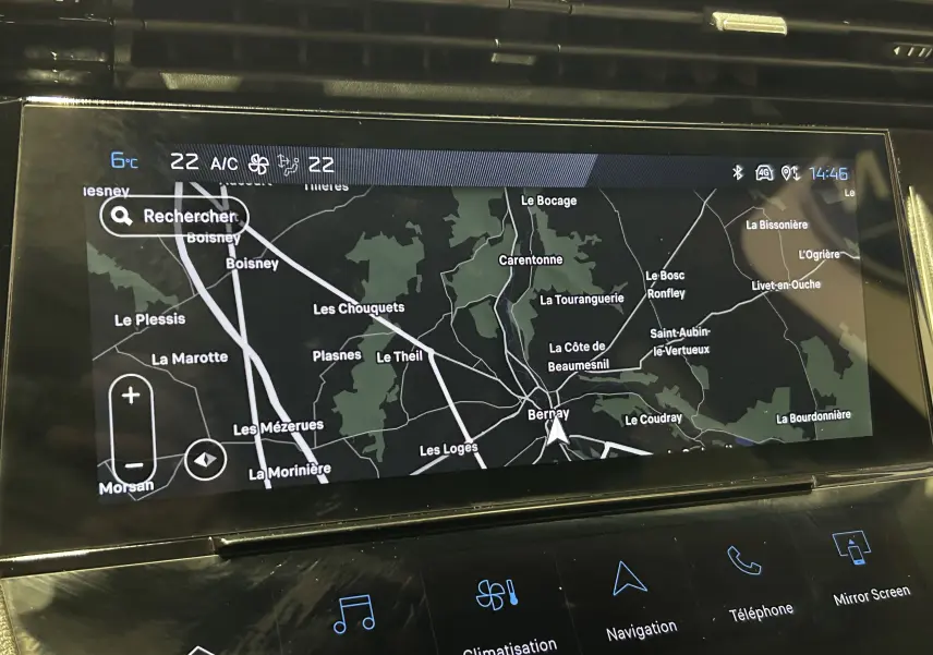 Gros plan sur l'écran tactile du GPS de la Peugeot 308 rouge 2024, affichant une carte de navigation détaillée.