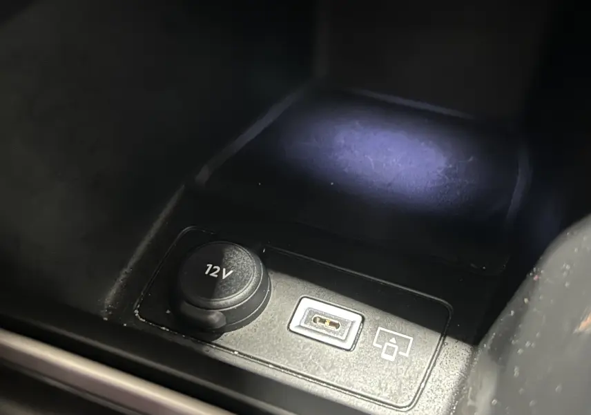 Détail intérieur montrant une prise 12V et un port USB dans une Peugeot 308 rouge de 2024.