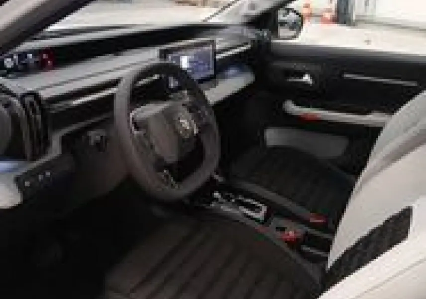Vue intérieure côté conducteur du Citroën C3 Aircross Hybrid 145, avec sièges noirs et tableau de bord moderne.