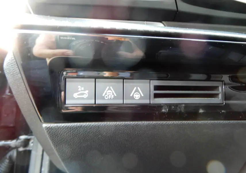 Gros plan sur les boutons de contrôle d’aide à la conduite dans l’habitacle d’une Peugeot 508 SW noire.