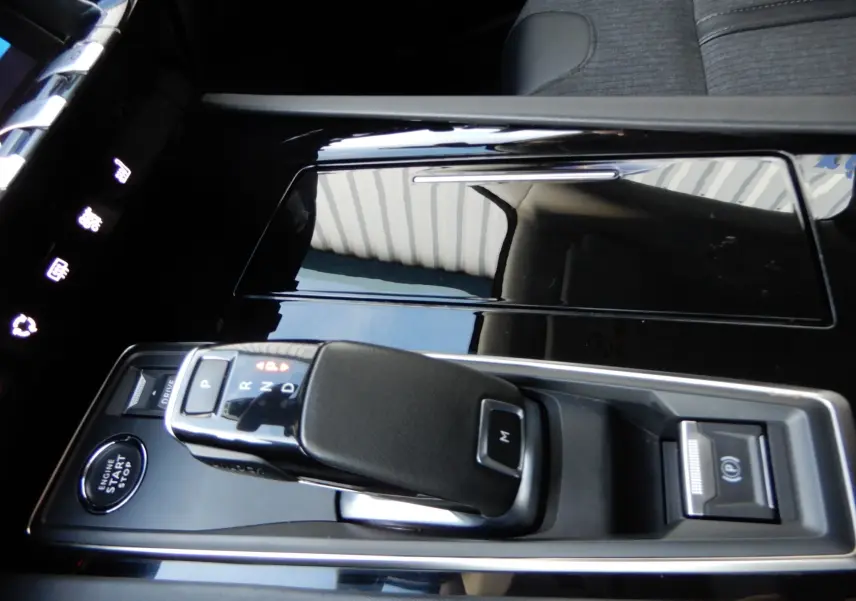 Gros plan sur la console centrale noire brillante de la Peugeot 508 SW Allure 2020 avec levier de boîte auto et bouton start-stop.