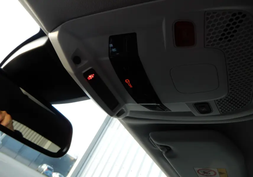 Vue intérieure du plafonnier et du rétroviseur d'un Peugeot 508 SW noir Perla Nera avec témoins lumineux rouges.