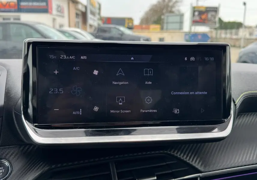 Écran tactile central affichant la climatisation et navigation dans l’habitacle d’une Peugeot 208 gris, vue de face.