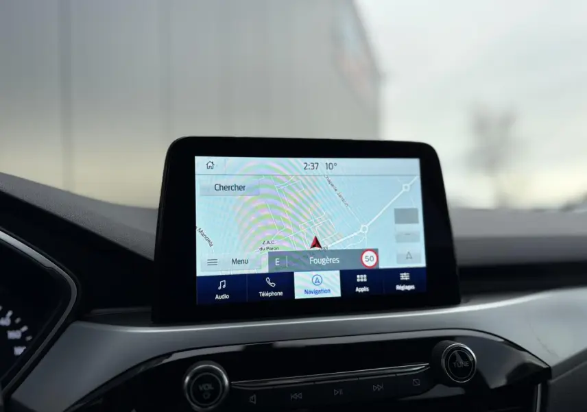 Écran tactile GPS du Ford Kuga 2024 affichant une carte de navigation, vue intérieure centrée sur la console.