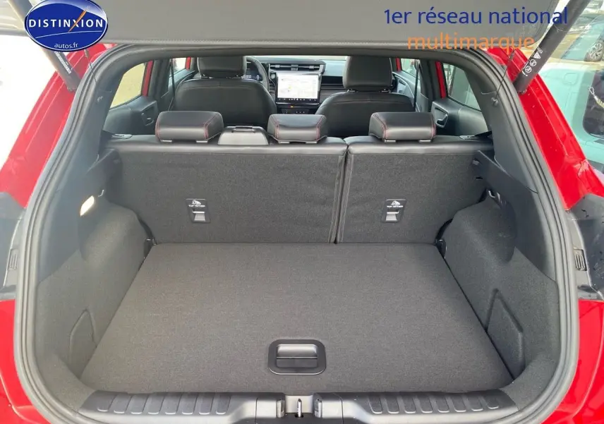 Coffre ouvert vu de l'arrière d'un Ford Puma rouge métallisé avec banquette arrière et intérieur noir visible.
