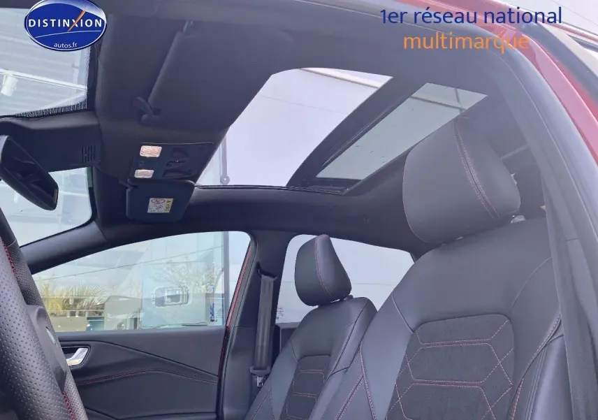 Vue intérieure côté gauche du Ford Puma rouge avec toit ouvrant panoramique et sièges sport noirs à surpiqûres rouges.