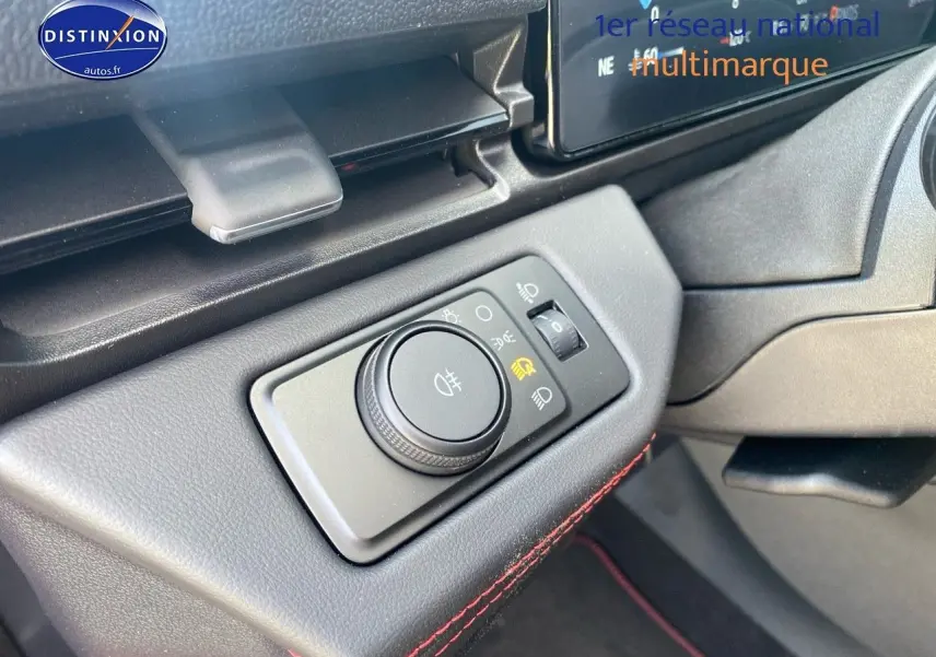 Détail du bouton de réglage des phares sur la gauche du tableau de bord du Ford Puma rouge.