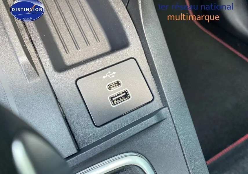 Gros plan sur les ports USB-C et USB-A dans la console centrale du Ford Puma, avec surpiqûres rouges visibles.