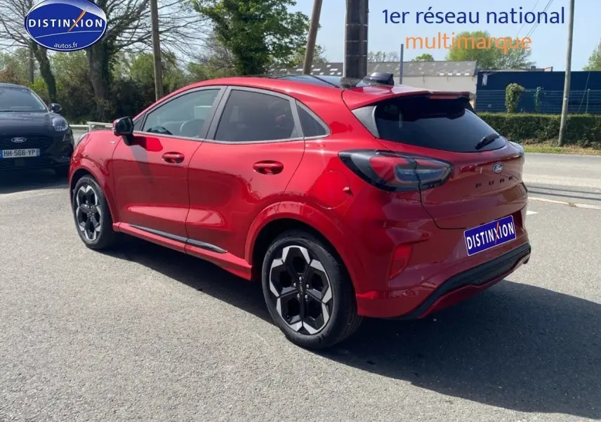 Vue 3/4 arrière droite d'un Ford Puma rouge métallisé avec jantes alu et vitres arrière surteintées.