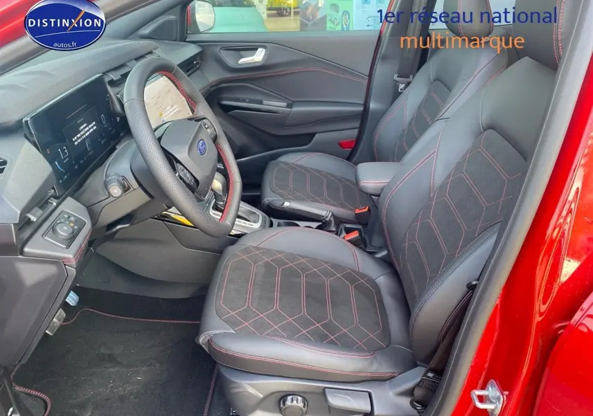Vue intérieure côté conducteur du Ford Puma rouge, mettant en valeur les sièges sport avec surpiqûres rouges et le volant multifonction.