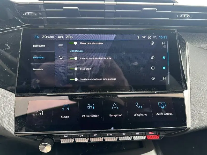 Écran tactile central de la Peugeot 308 Hybrid 2025 montrant les réglages d’aides à la conduite et climatisation.