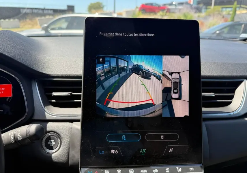 Vue intérieure du tableau de bord du Renault Captur 2025 avec écran tactile affichant la caméra de recul en marche.