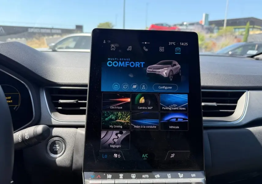 Vue intérieure centrée sur l'écran tactile vertical du tableau de bord du Renault Captur gris Rafale 2025.