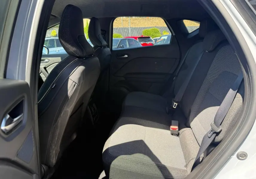 Vue intérieure côté droit des sièges arrière gris foncé du Renault Captur 2025 avec ceintures de sécurité visibles.