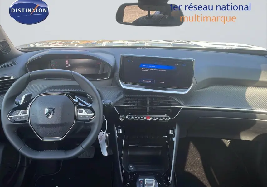 Vue intérieure frontale du tableau de bord du Peugeot 2008 Hybrid gris avec écran tactile et volant compact multifonction.