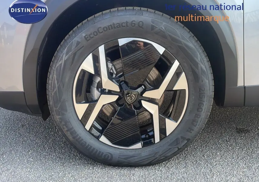 Gros plan sur la roue avant gauche du Peugeot 2008 gris Artense Metal, mettant en valeur la jante bi-ton moderne.