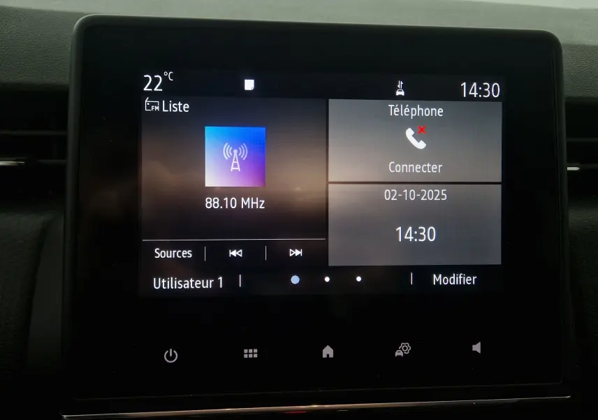 Écran tactile central de la Renault Clio V gris platine affichant la radio à 88,10 MHz et menu téléphone à 14h30.